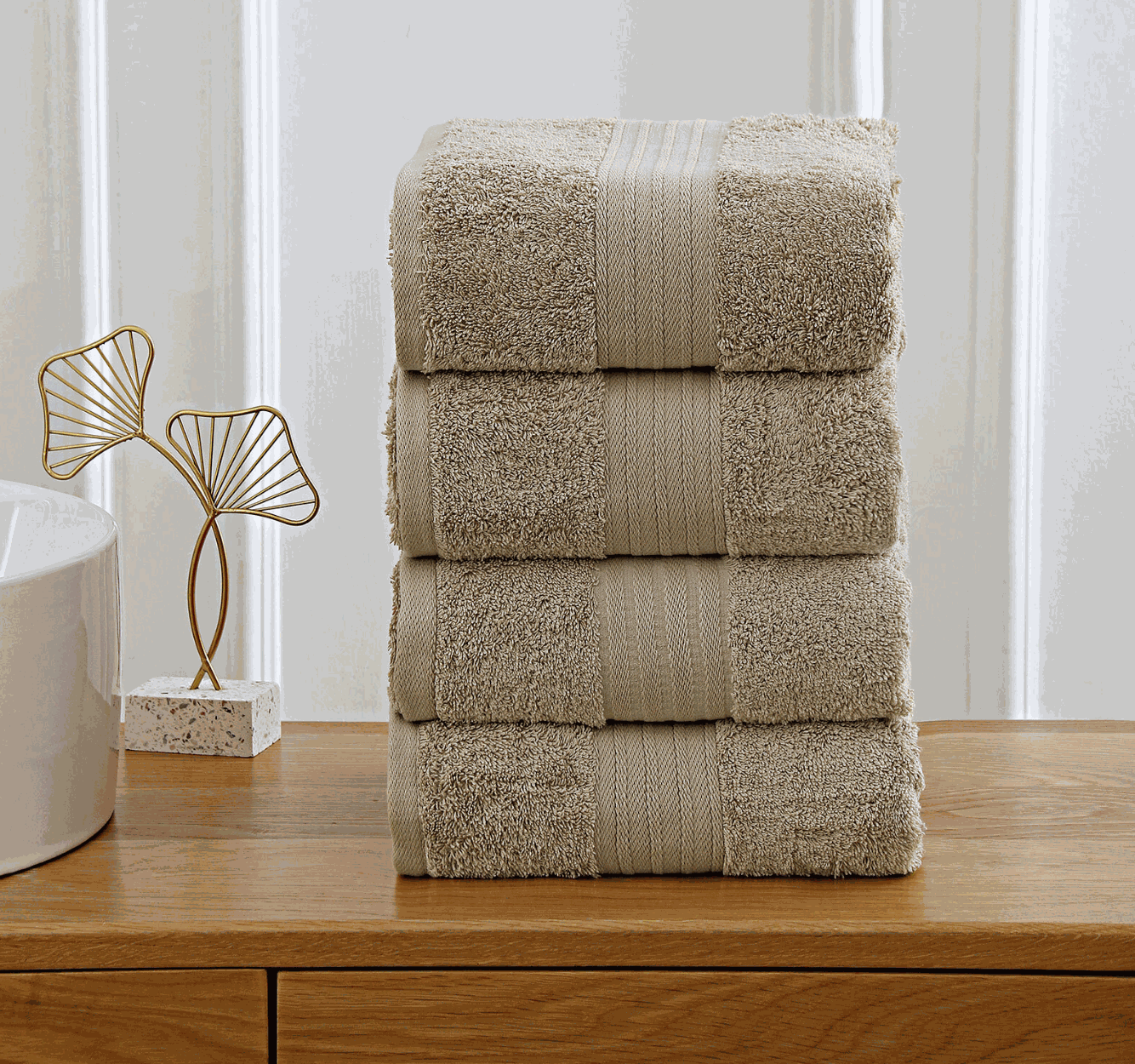beige towels stacked on wooden shelf