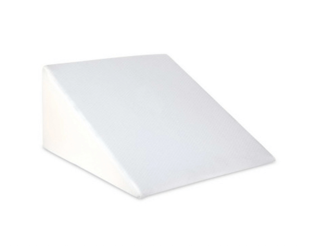 White wedge pillow for back, neck, and leg support.