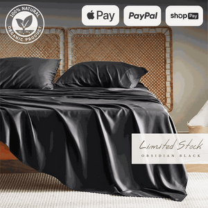 Luxurious black bamboo bed sheets draped over a bed, offering a sleek and modern look. These bamboo sheets are ultra-soft, breathable, and hypoallergenic, ensuring a comfortable and restful sleep experience