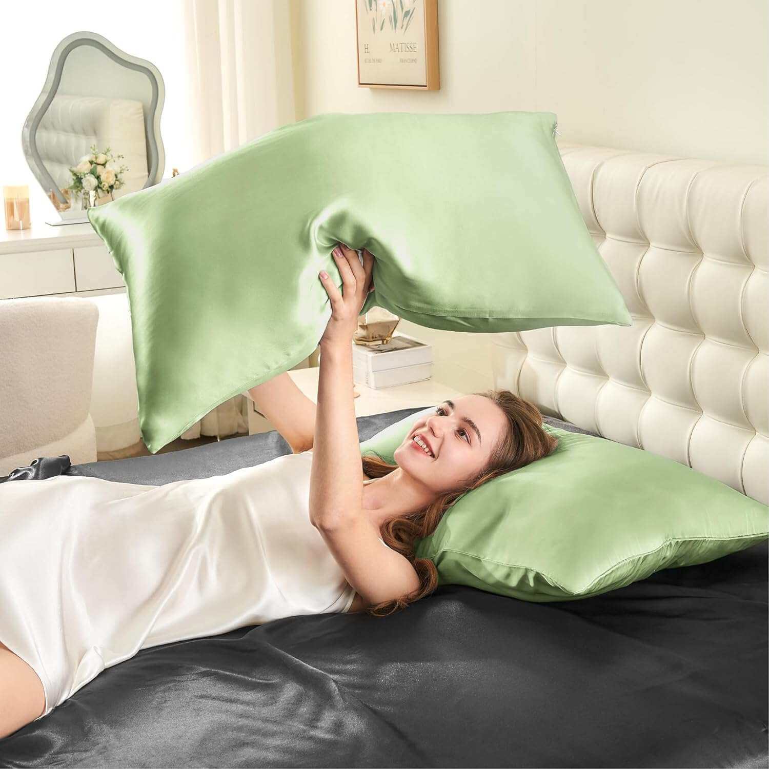 Woman joyfully tossing a light green silk pillow case in the air, highlighting its smooth, soft, and luxurious texture. This silk pillow case is designed for superior comfort, hair protection, and a breathable, skin-friendly sleep experience.