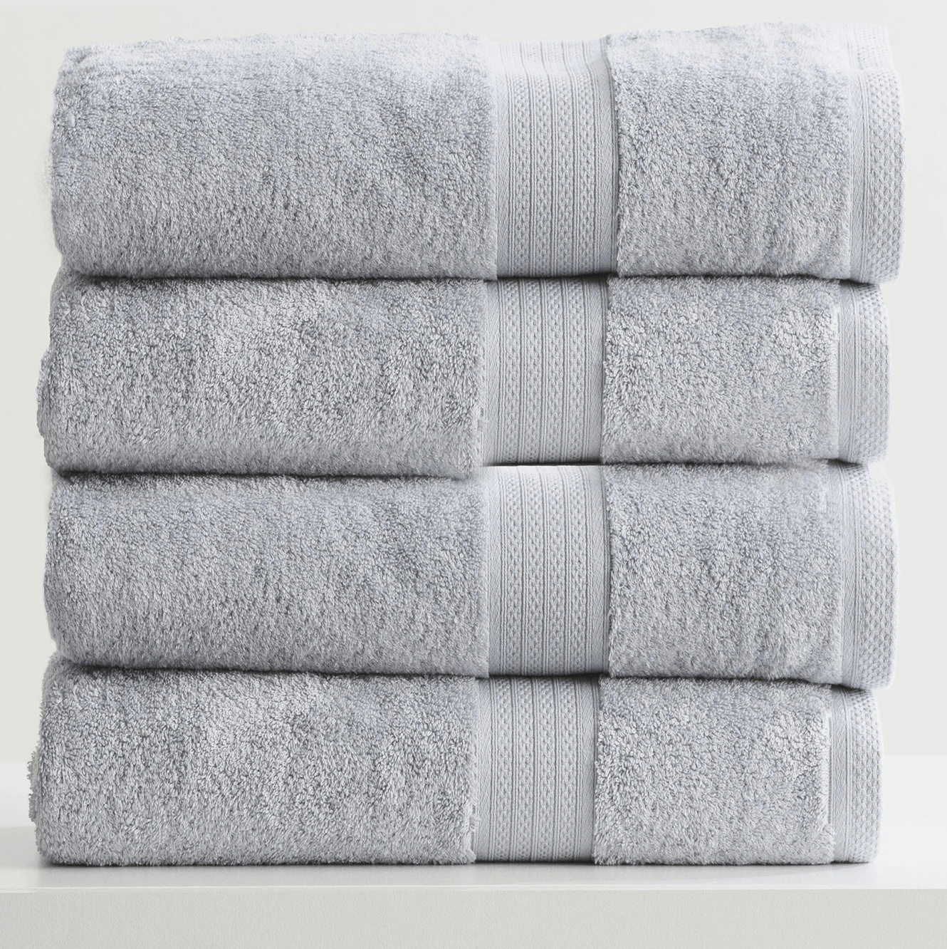 Stack of Adorearth™ organic bamboo towels in light gray color, showcasing soft and eco-friendly bathroom essentials.