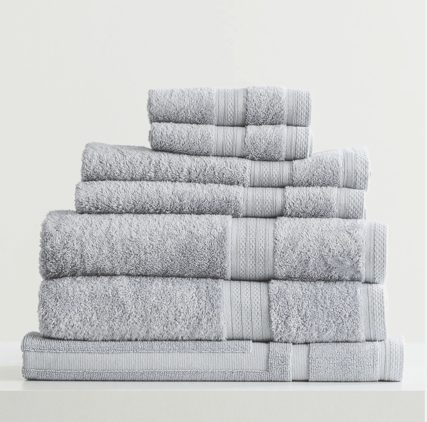 Stack of Adorearth™ organic bamboo towels in light gray color.